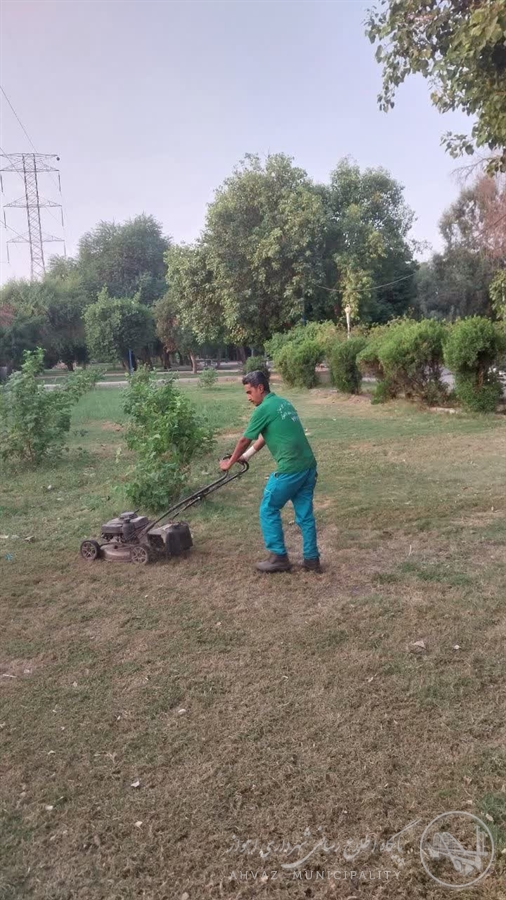 چمنزنی و پاکسازی فضای سبز پارک لاله توسط شهرداری منطقه هفت اهواز