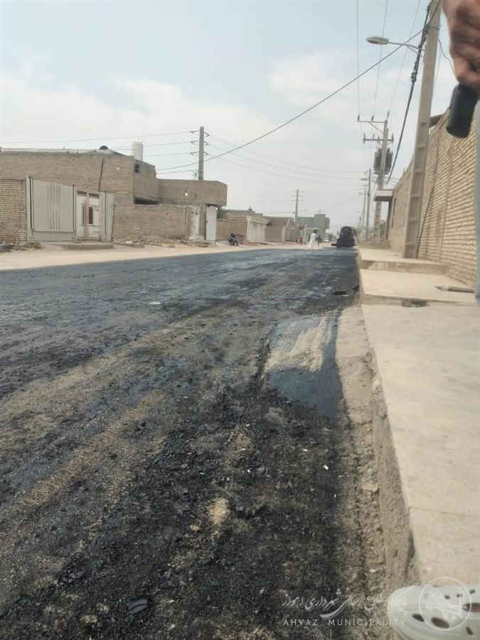 اجرای عملیات قیرپاشی در خیابان سوم غربی کوی عیندو برای آمادهسازی آسفالت